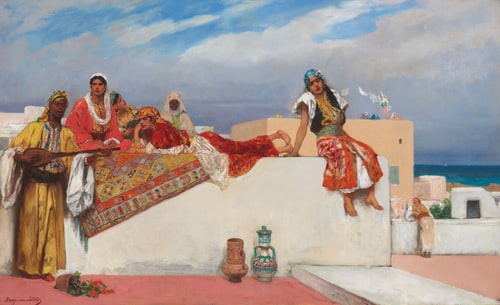 A group of people in colorful, traditional clothing relax on a sunlit terrace. The scene overlooks a coastal town with a bright blue sky.